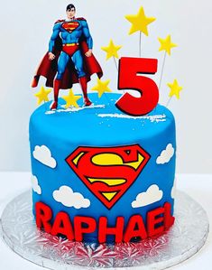 a birthday cake with a superman figure on top and stars in the sky around it