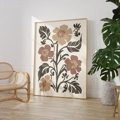 an art work is displayed on the wall next to a chair and potted plant