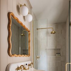 a white sink sitting under a bathroom mirror next to a walk in bathtub and shower