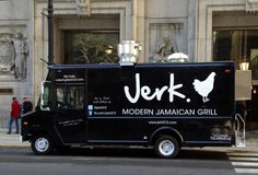 a food truck is parked on the side of the street in front of a building