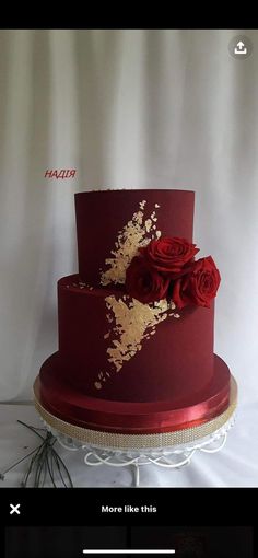 a red and gold wedding cake with roses on top