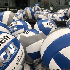 many volleyballs are stacked together in a pile