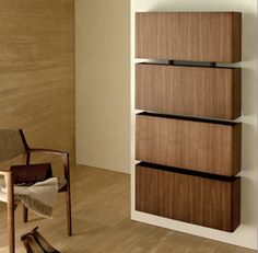 a wooden shelf sitting next to a chair on top of a hard wood floor