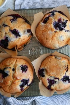 four blueberry muffins sitting on top of a pan