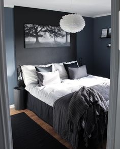 a black and white bedroom with a large painting on the wall above the headboard