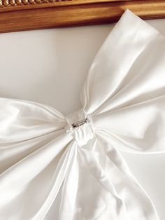 Elevate your bridal style with our Bella Bow. Designed with a coquette-like elegance, this bold yet feminine accessory is perfect for adding a touch of sophistication to your wedding dress, or dressing up a bridal shower outfit. The removable satin bow is the ultimate finishing touch for your special day. Details: Color: Light Ivory Detachable Bow Broach Pin Sewn on the back to secure to your dress Dimensions: Bow Width: Approximately 17 inches Bow Height: Approximately 9 inches Train Length: Ap Shower Outfits, Bridal Shower Outfit, Tulle Bows, Bride Hair Accessories, Light Ivory, Junior Bridesmaid, Satin Bow, Off White Color, Bridal Shop