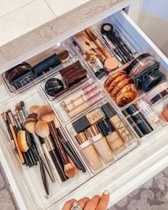 the drawers are filled with makeup and other beauty products, including eye shadows, mascaras, eyeshades, and more