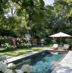 an outdoor pool surrounded by white flowers and greenery