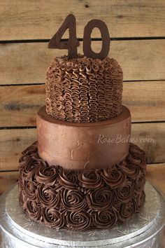 a three tiered chocolate cake with the number forty on top