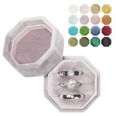 an open ring box with two rings in it and several colors of the ring inside