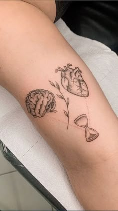 a woman with a tattoo on her leg has a heart and flowers in the shape of a brain