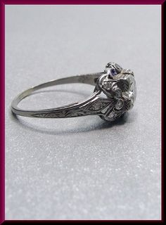 an antique style diamond ring with filigree accents