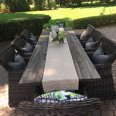 a wooden table sitting on top of a brick patio