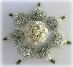 a bouquet of white roses and baby's breath flowers arranged in a circular arrangement