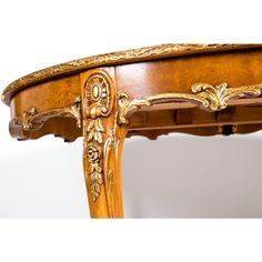 an ornately carved wooden table with gold leaf detail on the top and bottom edge