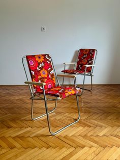 two chairs sitting on top of a hard wood floor next to a white wall and wooden floors