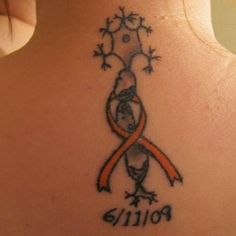 a woman with a tattoo on her back has an orange ribbon in the shape of a bird