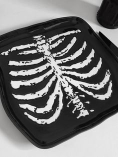 a black and white image of a skeleton on a tray