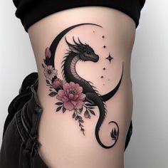 a woman's stomach with a dragon and flowers tattoo on her lower side ribcage