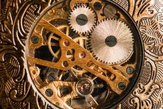 an intricately designed clock with two gears on it's face and the second gear visible