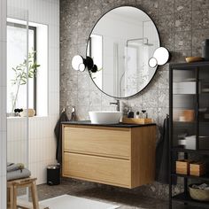 a bathroom with a sink, mirror and shelving unit