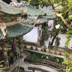 an aerial view of a building with many plants and trees in the foreground, surrounded by greenery