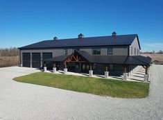 a large gray house with a black roof