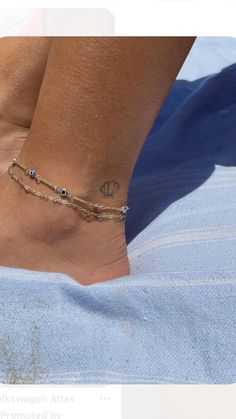 a woman's foot with a tattoo on it and a chain around the ankle