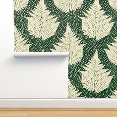 a green and white wallpaper with leaves on it in the corner of a room