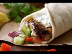 a wrap filled with meat, vegetables and sauce