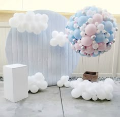 balloons are floating in the air next to a white box and some boxes on the ground