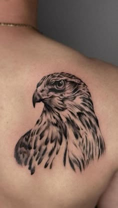 an eagle tattoo on the back of a woman's shoulder, with black and white ink