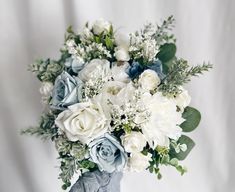 a bouquet of white and blue flowers in a vase