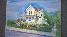 a watercolor painting of a white house with blue shutters and an american flag on the porch