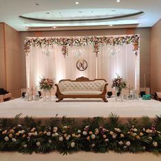 a couch sitting on top of a white table covered in flowers