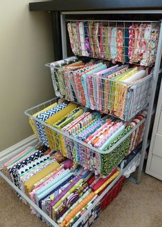 an organized closet with many different types of fabrics and fabric on the bottom shelf, along with several storage bins