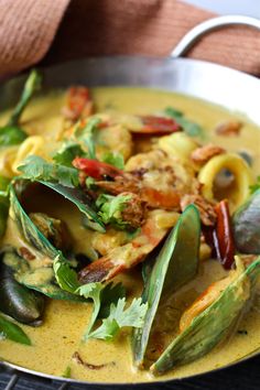 a close up of a plate of food with shrimp and mussels on it