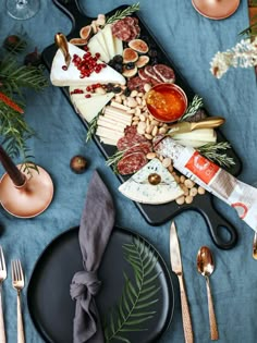 a wooden platter filled with different types of cheeses, meats and crackers