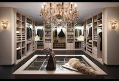 a walk in closet with chandelier and shoes on the floor, lights hanging from the ceiling