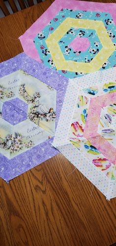 four quilts laid out on top of a wooden table