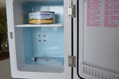 an open refrigerator with a can of cat food in it