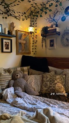 a teddy bear laying on top of a bed in a bedroom next to framed pictures