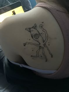 the back of a woman's shoulder with a tattoo design on her left side