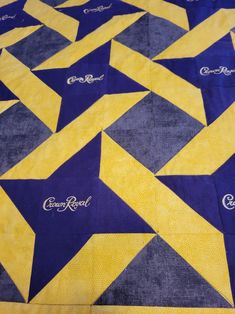 a yellow and blue quilt is laying on top of a tablecloth that has the words camp royal written on it