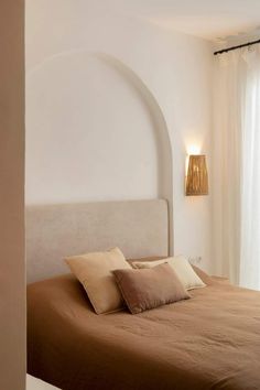 a bed sitting in a bedroom next to a window with curtains on the outside wall