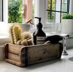 a wooden box filled with different types of cleaning products on top of a white counter