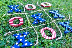 patriotic wooden letters tied to string in the grass with an american flag pattern on them