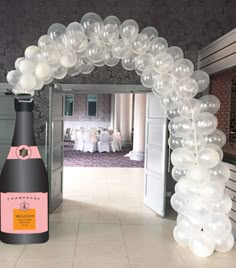 an arch made out of balloons and a bottle of champagne