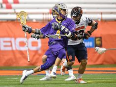 two lacrosse players are playing on the field