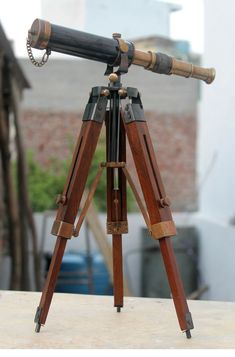 an old fashioned telescope sitting on top of a table